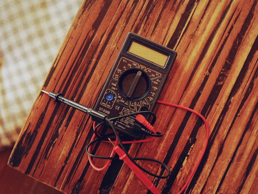 Reconditioned digital multimeter with test leads on a service workbench